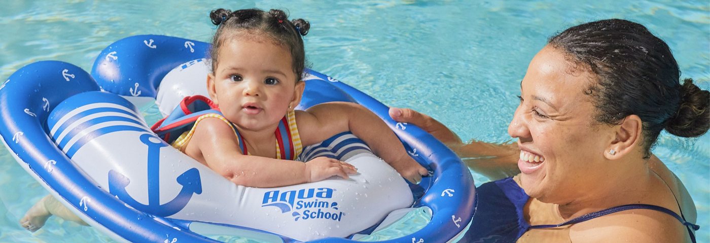 Baby in a SwimSchool baby float with mom in the pool