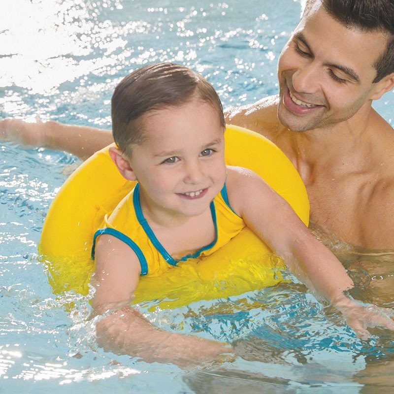 Toddler in a SwimSchool swim trainer with dad in the pool